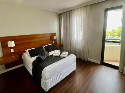 um quarto com uma cama grande e uma janela em Belíssimo FLAT - Faria Lima - Pinheiros em São Paulo