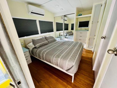 um quarto com uma cama e uma televisão em Sunshine Tiny Home Pinecraft em Sarasota