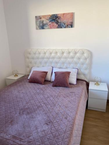 a bedroom with a large bed with two pillows at Dream Apartment in Lukavica