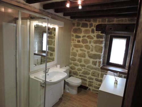 baño con lavabo y aseo y ventana en Casa rural La Bárcena Saja, 