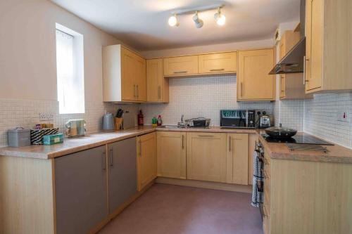 eine große Küche mit gelben Schränken und einem Fenster in der Unterkunft Spacious Apartment, Near Birmingham Centre + NEC in Birmingham