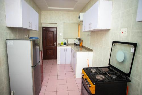 a kitchen with a stove in the middle of it at House 55 Apartments in Abuja