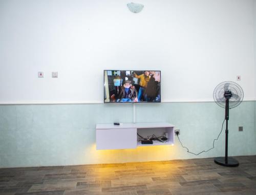 a room with a white table and a fan at House 55 Apartments in Abuja