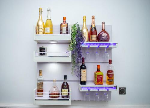 a shelf filled with lots of bottles of alcohol at House 55 Apartments in Abuja