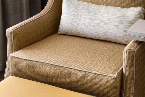 a brown chair with a pillow and a table at Hilton Garden Inn Flagstaff in Flagstaff