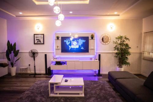 a living room with a tv and a couch at House 55 Apartments in Abuja