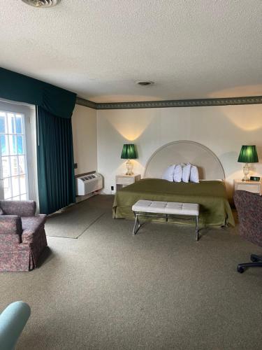 a bedroom with a bed and a couch and a table at Knights Inn Mackinaw City in Mackinaw City