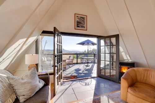 a living room with an open door to a patio at Jefferson A-Frame Cabin with Rocky Mountain Views in Bordenville