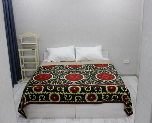 uma cama com um cobertor preto e vermelho em MIRAMEL HOME Centro em Yakkasaray