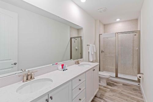een witte badkamer met een wastafel en een douche bij 2959 Castaway Lane in Orlando
