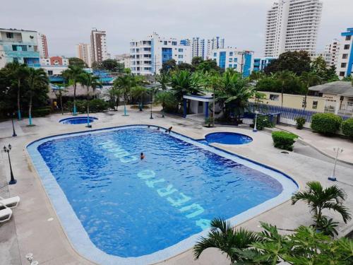 a large swimming pool in a city with tall buildings at Departamento bonito y comodo en Tonsupa in Tonsupa