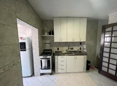 cocina con nevera blanca y fregadero en Apartamento 3 quartos Rio, en Río de Janeiro