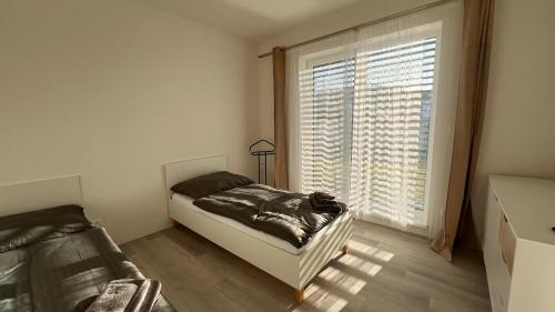 um quarto com uma cama e uma grande janela em Klimatizovaný Apartmánový dom s vírivkou, 9B em Jánošíková