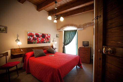 a bedroom with a red bed and a window at Albergo Tripoli B&B Affittacamere in Corato