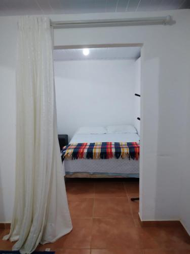 - une chambre avec un lit et un rideau blanc dans l'établissement Sitio Café Bela Colina, à Sylvestre Ferraz