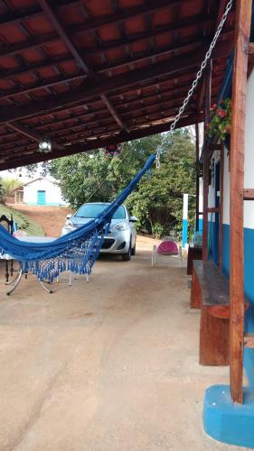 - un hamac bleu dans un parking avec une voiture dans l'établissement Sitio Café Bela Colina, à Sylvestre Ferraz