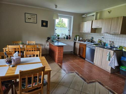 a kitchen with a table and a dining room at Noclegi u Przewodników - Zwiedzaczek in Lubawka