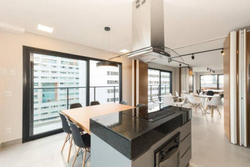 une cuisine avec un comptoir et une table avec des chaises dans l'établissement Apartamento - Batel/Água Verde - Shopping Curitiba, à Curitiba