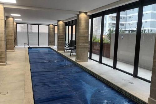 a swimming pool in the middle of a building with windows at Apartamento - Batel/Água Verde - Shopping Curitiba in Curitiba