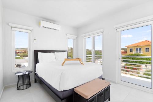 a white bedroom with a bed and two windows at San Fuego 28-W in Santa Cruz
