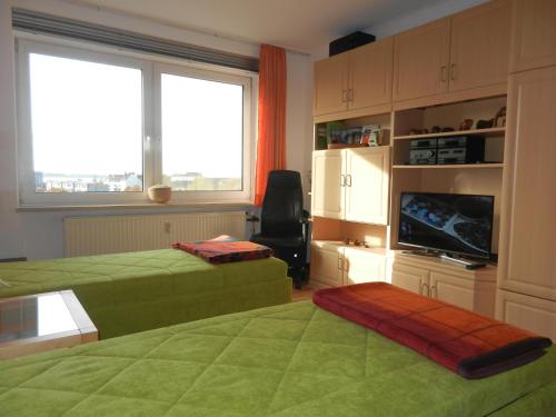a living room with two beds and a television at Ferienwohnung AMBIENTE in Bremerhaven