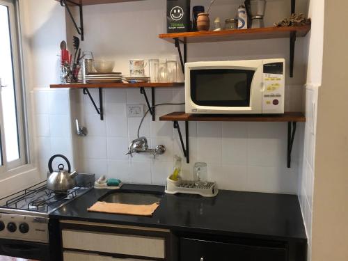 La cocina está equipada con fogones y microondas. en Bonito departamento zona Guemes en Mar del Plata