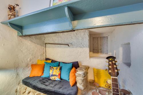a room with a guitar and a couch with pillows at Jim Croces Farmhouse Apartment in Downingtown! in Downingtown