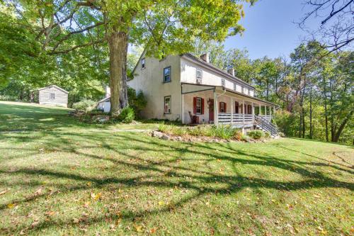 a large house on a grassy hill with a tree at Jim Croces Farmhouse Apartment in Downingtown! in Downingtown