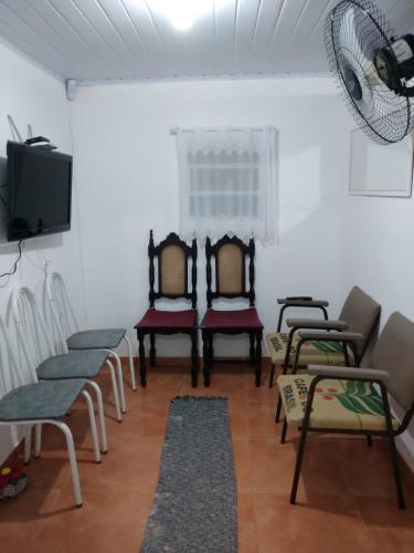 Cette chambre dispose de chaises et d'une télévision à écran plat. dans l'établissement Sitio Café Bela Colina, à Sylvestre Ferraz