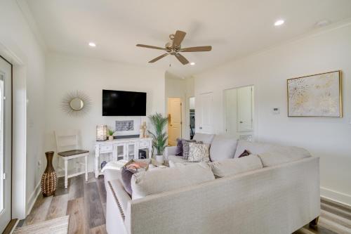 a living room with a white couch and a ceiling fan at Waterfront Pass Christian Paradise 1 Mi to Beach in Pass Christian
