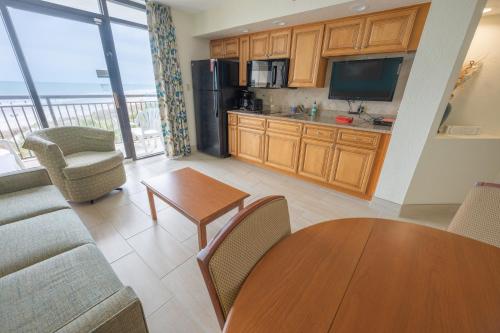 a living room with a couch and a table and a kitchen at Resort condo w balcony & hot tubs in Myrtle Beach