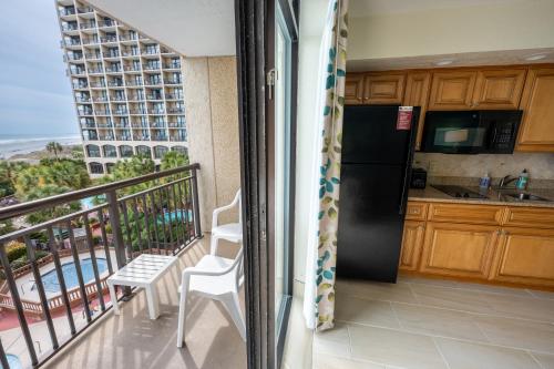 a kitchen with a refrigerator and a balcony with a view at Resort condo w balcony & hot tubs in Myrtle Beach