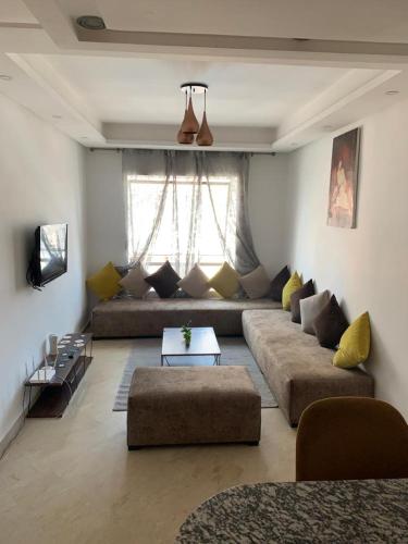 a living room with a couch and a table at Appartement Meublée in Casablanca