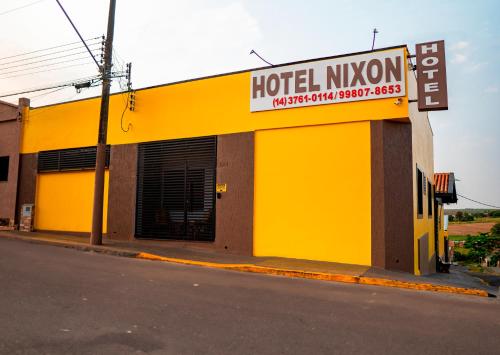 a yellow building with a hotel kingdom sign on a street at Hotel Nixon Próximo, Rodoviária, Prefeitura e a Matriz central in Itaí