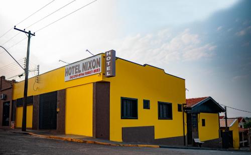 a yellow building with a sign on the side of it at Hotel Nixon Próximo, Rodoviária, Prefeitura e a Matriz central in Itaí