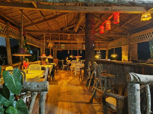 um restaurante com mesas e cadeiras num piso de madeira em Hidden Valley em Siquijor