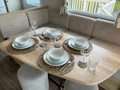 una mesa con platos y vasos con un sofá en High View, en Torquay