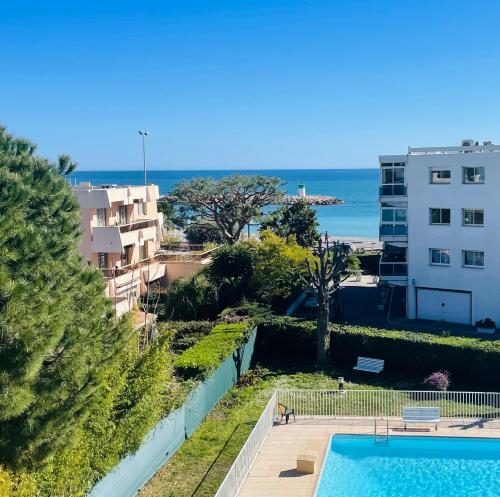 a view of a swimming pool and the ocean at Résidence méditerranée - Beachfront - Sun and Seaview - Pool - Private Parking in Cagnes-sur-Mer