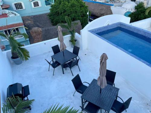 a patio with a table and chairs next to a swimming pool at MAYAB Playa - 5Th. Ave in Playa del Carmen