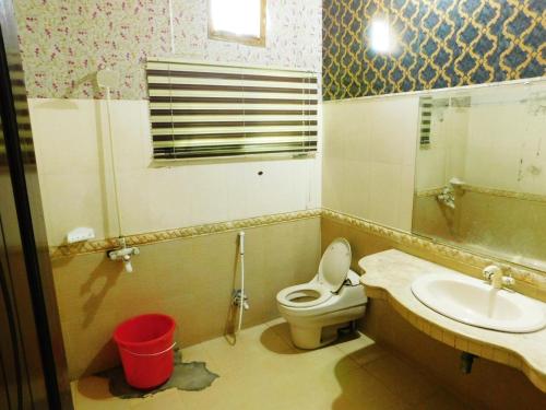 ein Bad mit einem WC und einem Waschbecken in der Unterkunft Moon Palace Hotel Lahore in Lahore