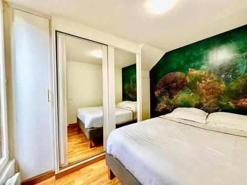 een slaapkamer met 2 bedden en een schilderij aan de muur bij GREENWOOD CHATOU - 1 chambre - 4 Pers - Wifi in Chatou
