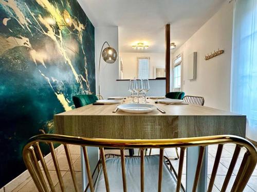 una sala da pranzo con tavolo e sedie in legno di GREENWOOD CHATOU - 1 chambre - 4 Pers - Wifi a Chatou