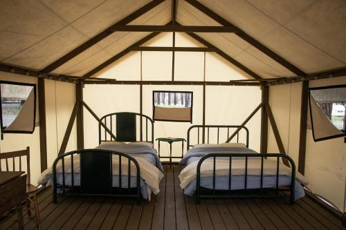 LyttonにあるKumsheen Rafting Resortのテント内のベッド2台が備わる部屋