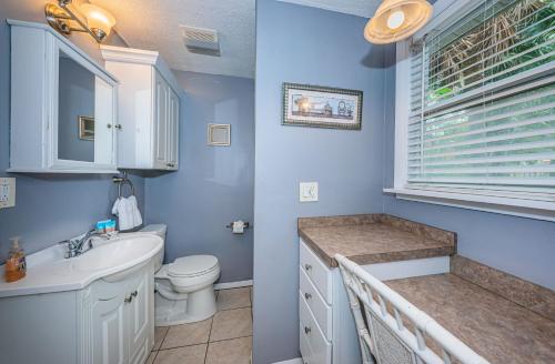 a blue bathroom with a toilet and a sink at Sunset Beach Bungalow 1 in St Pete Beach