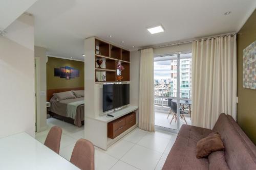 een slaapkamer met een bed en een televisie in een kamer bij Studios Modernos no Setor Bueno WBU in Goiânia