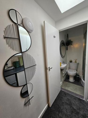 een badkamer met een spiegel naast een toilet bij Luxury Studio Stevenage in Stevenage