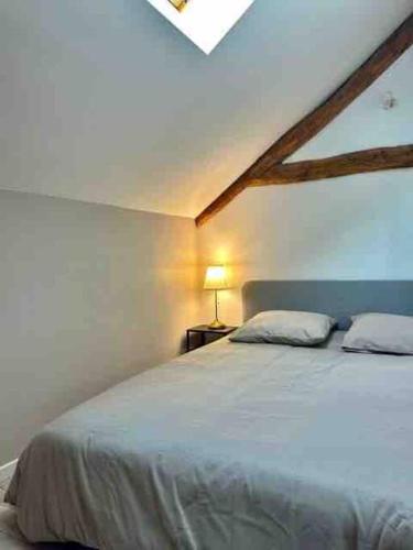 une chambre avec un grand lit blanc dans une pièce dans l'établissement Charme et calme, 45 min de Paris Gare de Lyon, à Vernou-sur-Seine