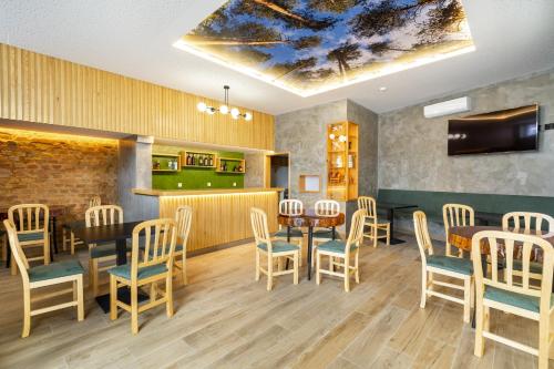 a restaurant with tables and chairs and a bar at FOREST VILLAS - GUEST HOUSE in Leiria