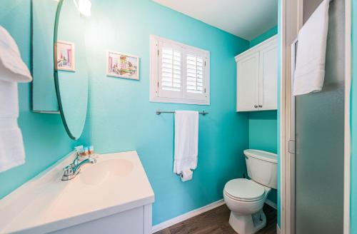 a blue bathroom with a toilet and a sink at Sunset Beach Bungalow 2 in St Pete Beach