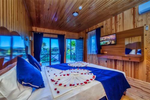 a bedroom with a large bed with blue sheets and blue pillows at Diamond Lord Bungalow in Alanya